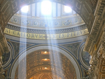 Rays of sunlight filter through windows in the dome of St. Peter's Basilica