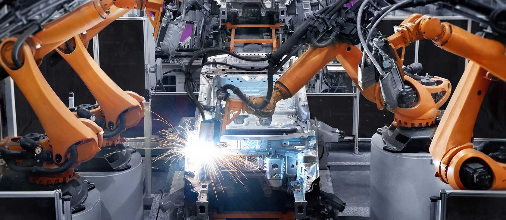 Robotic welders building a car on an automated assembly line